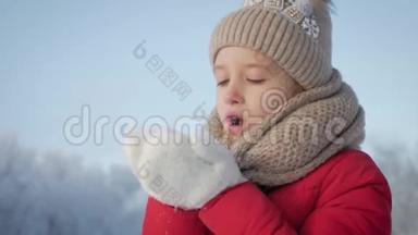 快乐的年轻女孩玩得开<strong>心</strong>，在美丽的冬日享受新鲜的雪。 戴着温<strong>暖</strong>手套的女孩吹雪。 户外<strong>活动</strong>